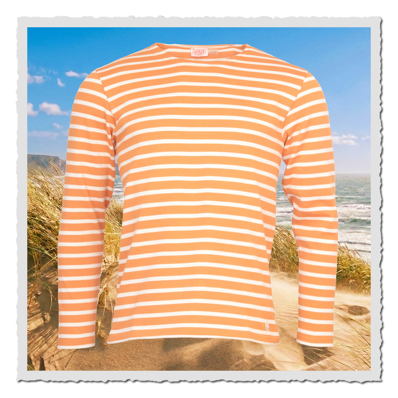 Gestreiftes Armor Lux Langarmshirt in Rost-Orange und Naturweiss, maritimer Look mit geradem Schnitt, Heritage-Anker am linken Saum vor Dünenlandschaft am Meer.